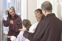Family waiting for the bathroom displaying a range of emotions